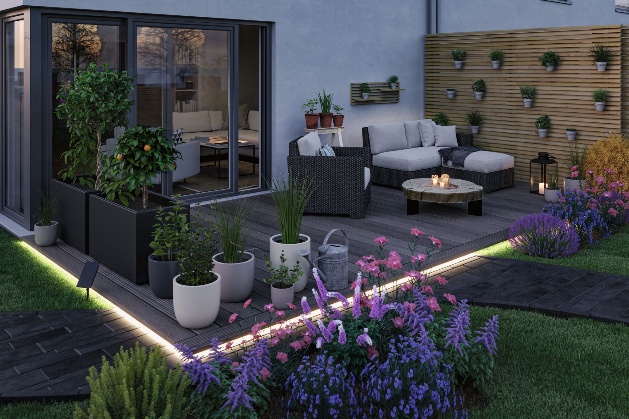 Modern terrace with LED floor lighting, grey rattan seating and colorful garden flowers in evening light.