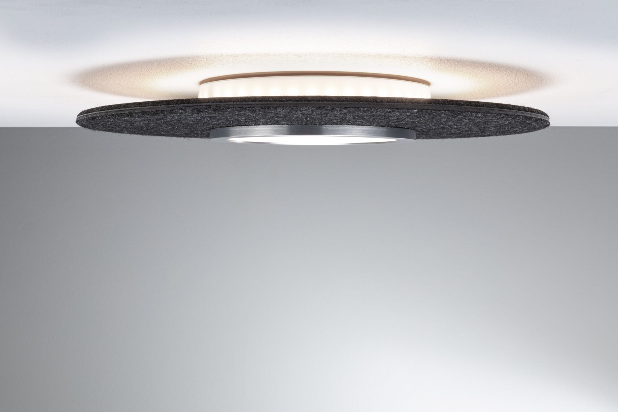 Plafonnier moderne avec anneau en feutre noir et aluminium au design minimaliste pour espaces de vie.