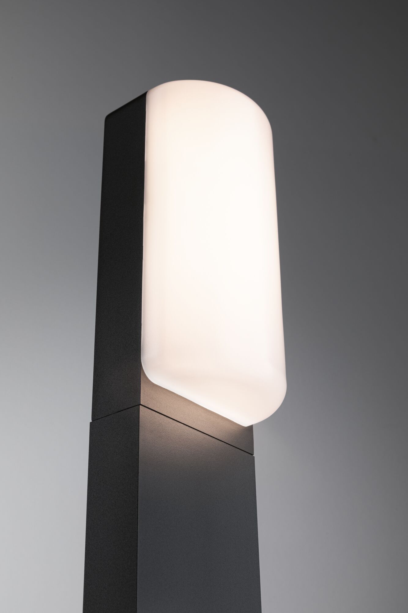 Moderne buitenlamp met zwarte metalen behuizing en wit opaalglas voor tuinverlichting.