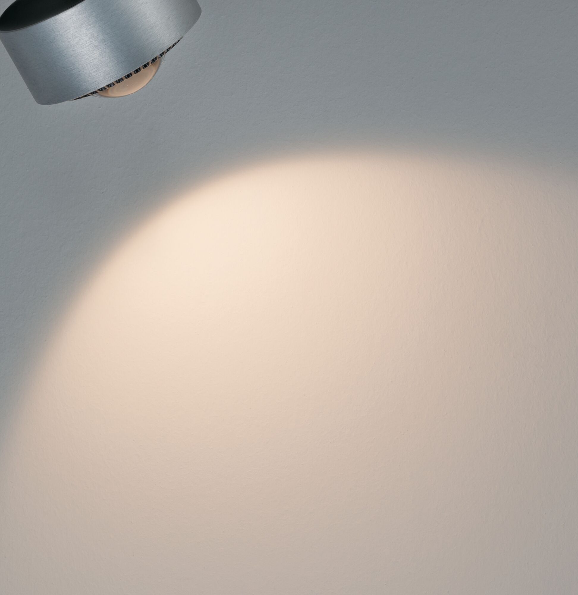 Modern LED wall spotlight in brushed aluminum with warm white light for living spaces