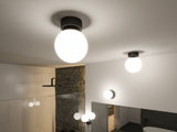 Modern round ceiling lights with matte black base and white glass in stylish bathroom setting.