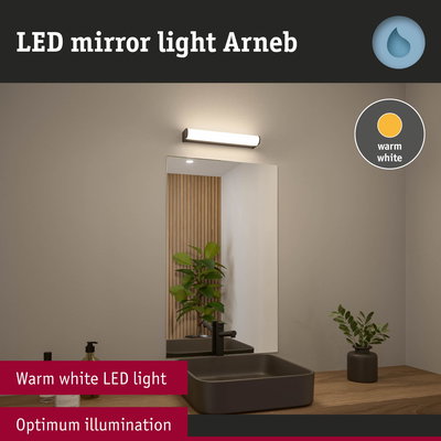 LED mirror light Arneb with warm white illumination above black sink on wooden countertop