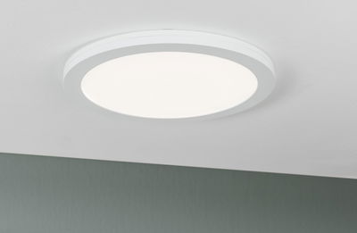 Round white LED ceiling light with matte diffuser for modern room lighting and energy-saving illumination.