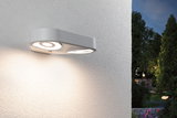 Moderne weiße Außenwandleuchte mit zwei runden LED-Leuchten an Hauswand im Garten