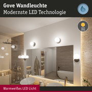 Gove Wandleuchte mit warmweißem LED-Licht in modernem Badezimmer mit Natursteinwand und Spiegel