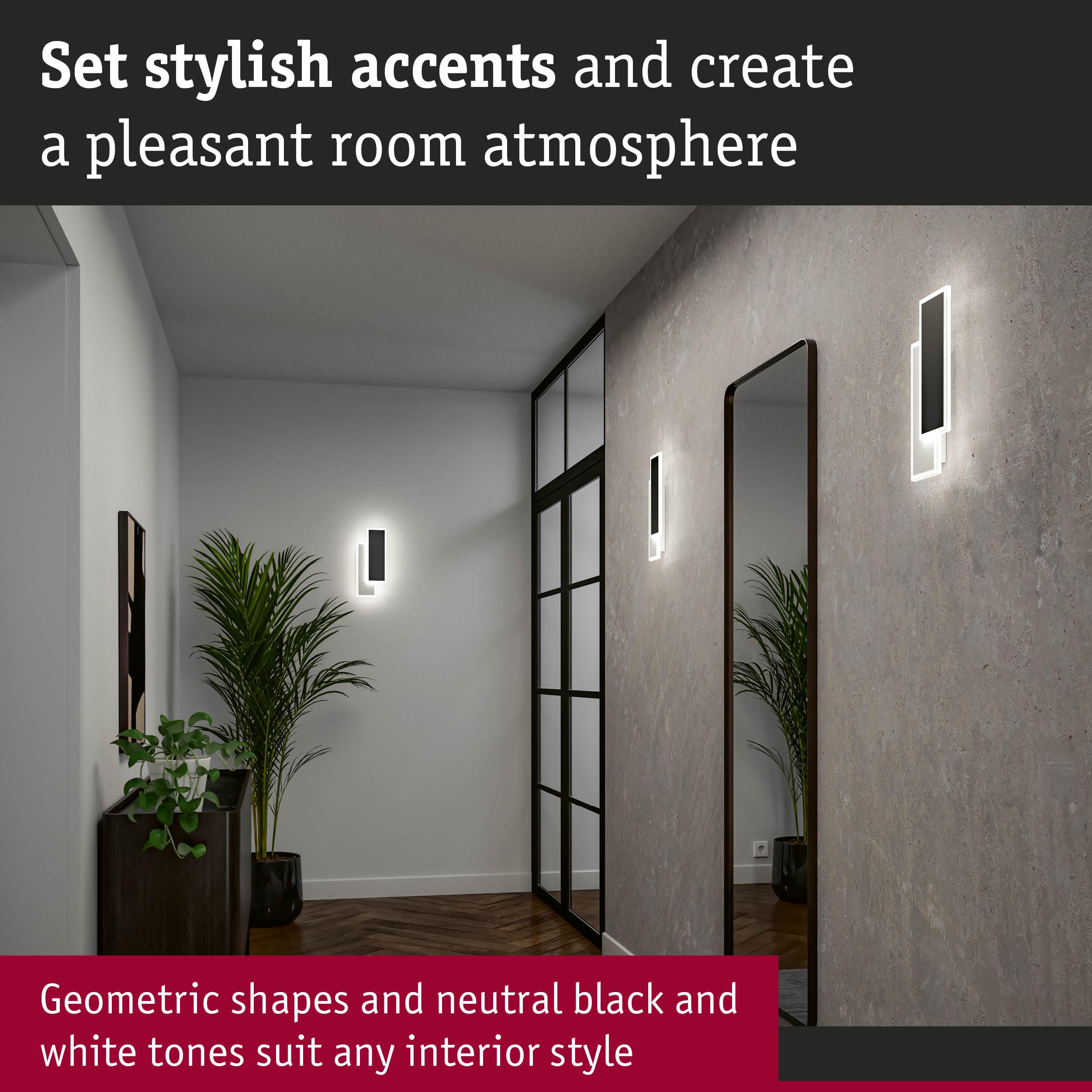 Modern hallway with geometric black and white wall lights and large mirror creating stylish room accents