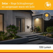 Zonne-energie buitenlamp met warm wit licht aan moderne gevel, energiezuinige LED-verlichting