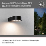 Schwarze LED-Außenwandleuchte mit austauschbarem Modul an weißer Wand, energiesparende LED-Technik