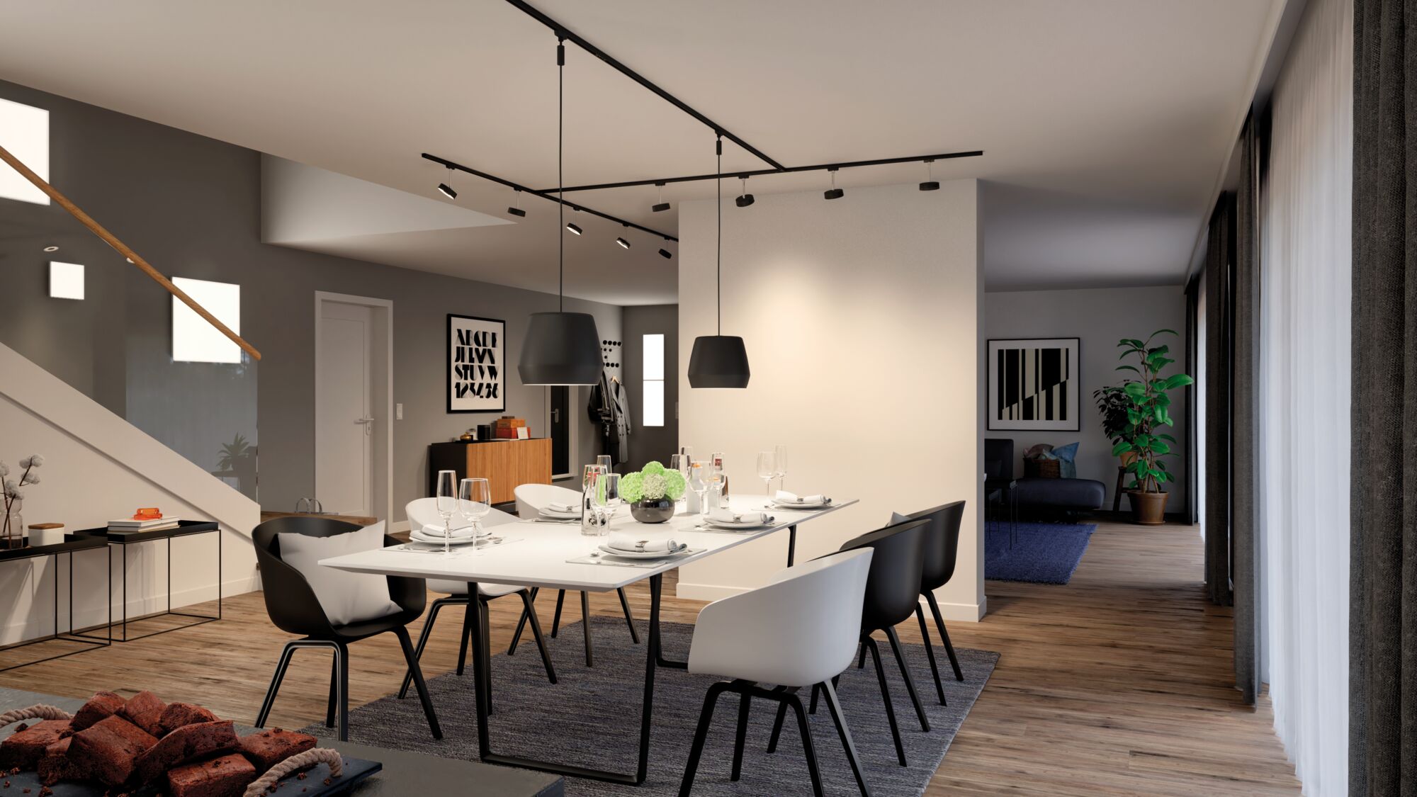 Salle à manger moderne avec chaises noires et blanches, suspensions et sol en bois éclairé