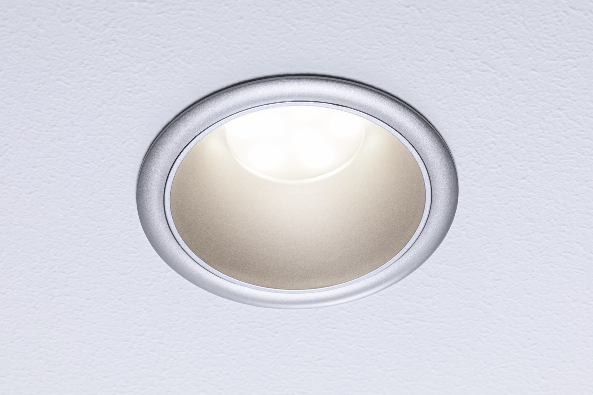 Round LED recessed spotlight with silver aluminum frame and warm white light for living spaces