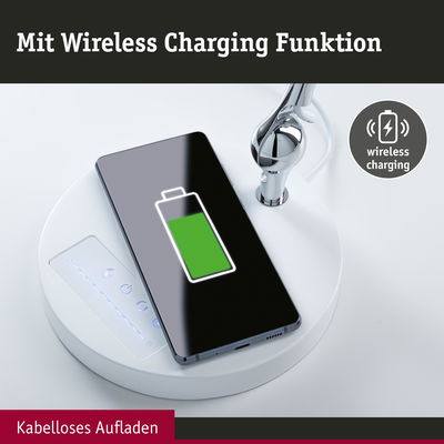 Weißer runder Lampenfuß mit kabelloser Ladefunktion und Smartphone mit grünem Akku-Symbol