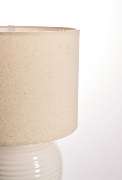 Beige linen lampshade with cream ceramic base for elegant home lighting and decor
