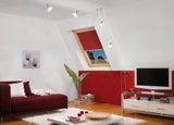 Salon moderne avec canapé rouge, tapis blanc et spots plafond à câble Paulmann blancs.