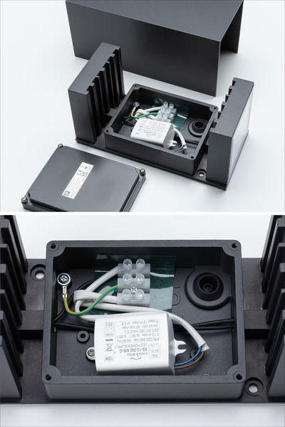Black aluminium housing with open LED driver and terminal block for outdoor light fixture