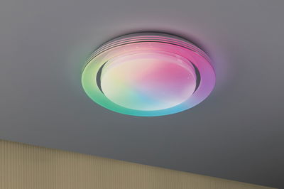 Runde Deckenleuchte mit mehrfarbigem LED-Licht und weißem Kunststoffschirm für moderne Raumbeleuchtung