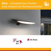 Schwarze Solar-Wandleuchte mit Bewegungsmelder an grauer Wand, energiesparende Außenbeleuchtung