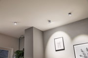 Drei weiße LED-Deckenstrahler aus Metall in modernem Wohnzimmer mit minimalistischer Wanddekoration
