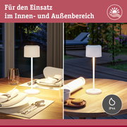 Weiße Tischlampe mit geriffeltem Schirm auf Holzplatte, geeignet für Innen- und Außenbereich mit IP44 Schutz