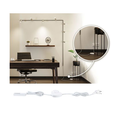 Hvid forlængerledning med kontakt til LED-lyslister i moderne kontor med træbord