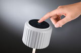 White ribbed LED light with touch-sensitive black control panel for modern lighting solutions.
