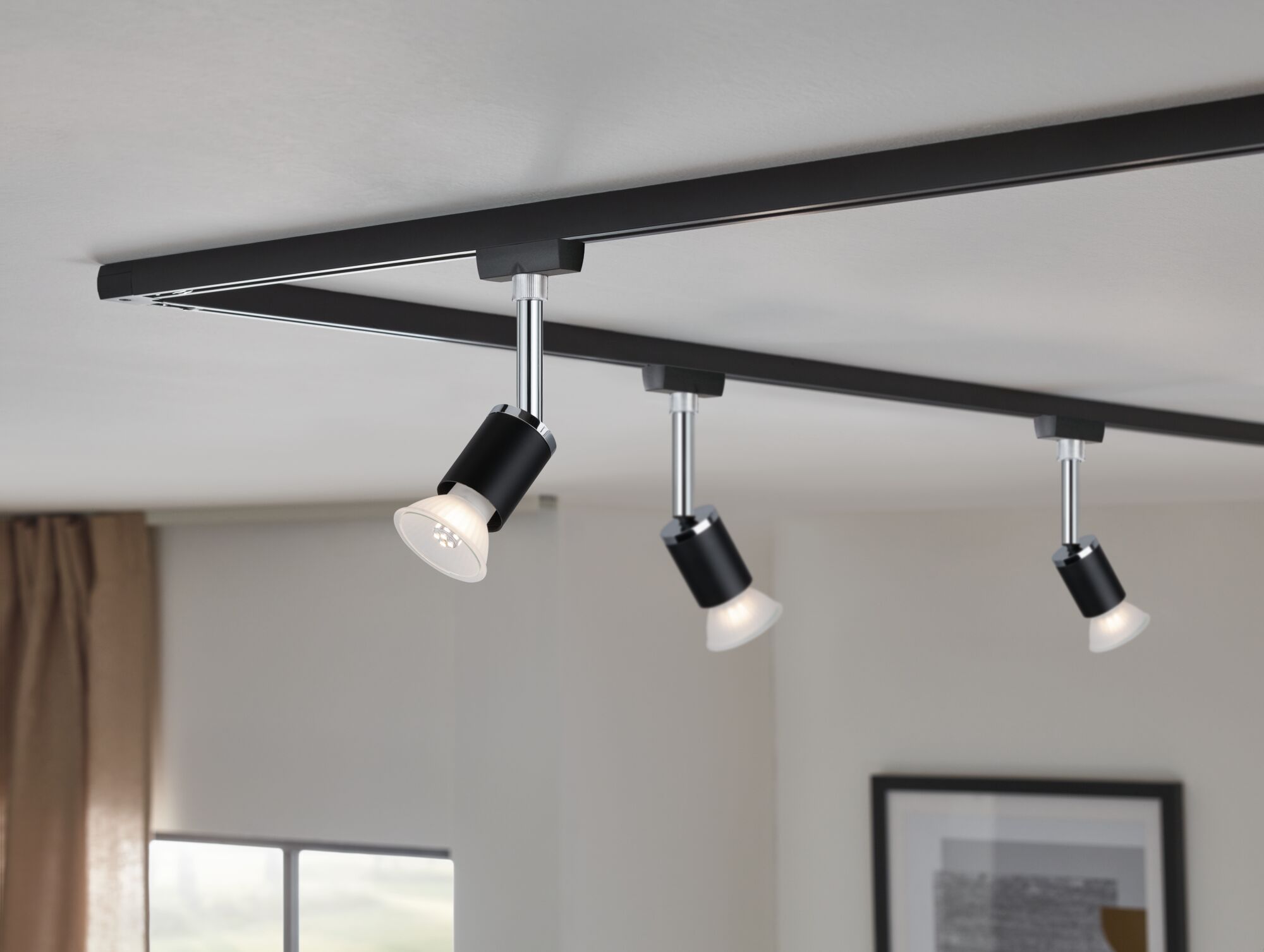 Système de rails LED noir en métal avec trois spots réglables pour un éclairage moderne