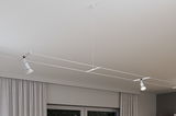 Modern white cable lighting system with two adjustable LED spotlights on ceiling for flexible lighting