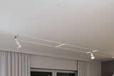 Modernes weißes Seilsystem mit zwei verstellbaren LED-Strahlern an der Decke für flexible Beleuchtung