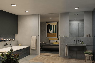 Modern bathroom with grey stone wall, recessed ceiling lights, and bathtub with blue tiles