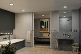 Modern bathroom with grey stone wall, recessed ceiling lights, and bathtub with blue tiles