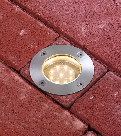 Ronde LED grondinbouwspot van roestvrij staal ingebed in rood straatwerk voor buitenverlichting