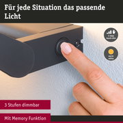 Finger bedient schwarzen Dimmschalter an Wandlampe mit 3-Stufen-Dimmung und Memory-Funktion