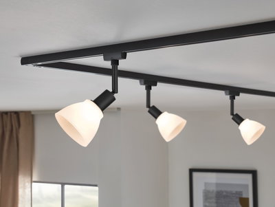 Three-light black track lighting with white glass shades for modern home illumination
