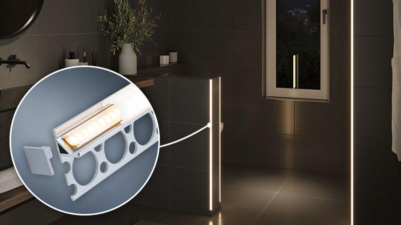 LED-lysstribe med aluminiumsramme i varmt hvidt monteret i moderne badeværelse med mørke fliser