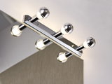 Chroomkleurige wandlamp met vier ronde lampen boven een spiegel voor badkamerverlichting