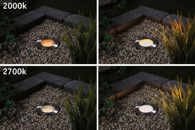 Vier roestvrijstalen inbouwgrondlampen met warme lichtkleuren 2000K en 2700K in grindbed.