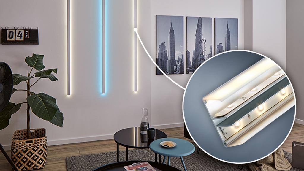 Moderne LED-Wandleuchten in Weiß und Blau in Wohnzimmer mit Holzfußboden und schwarzem Tisch, LED-Streifen Detail.