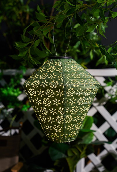 Green paper lantern with floral cutout pattern and metal handle, decorative outdoor garden lighting