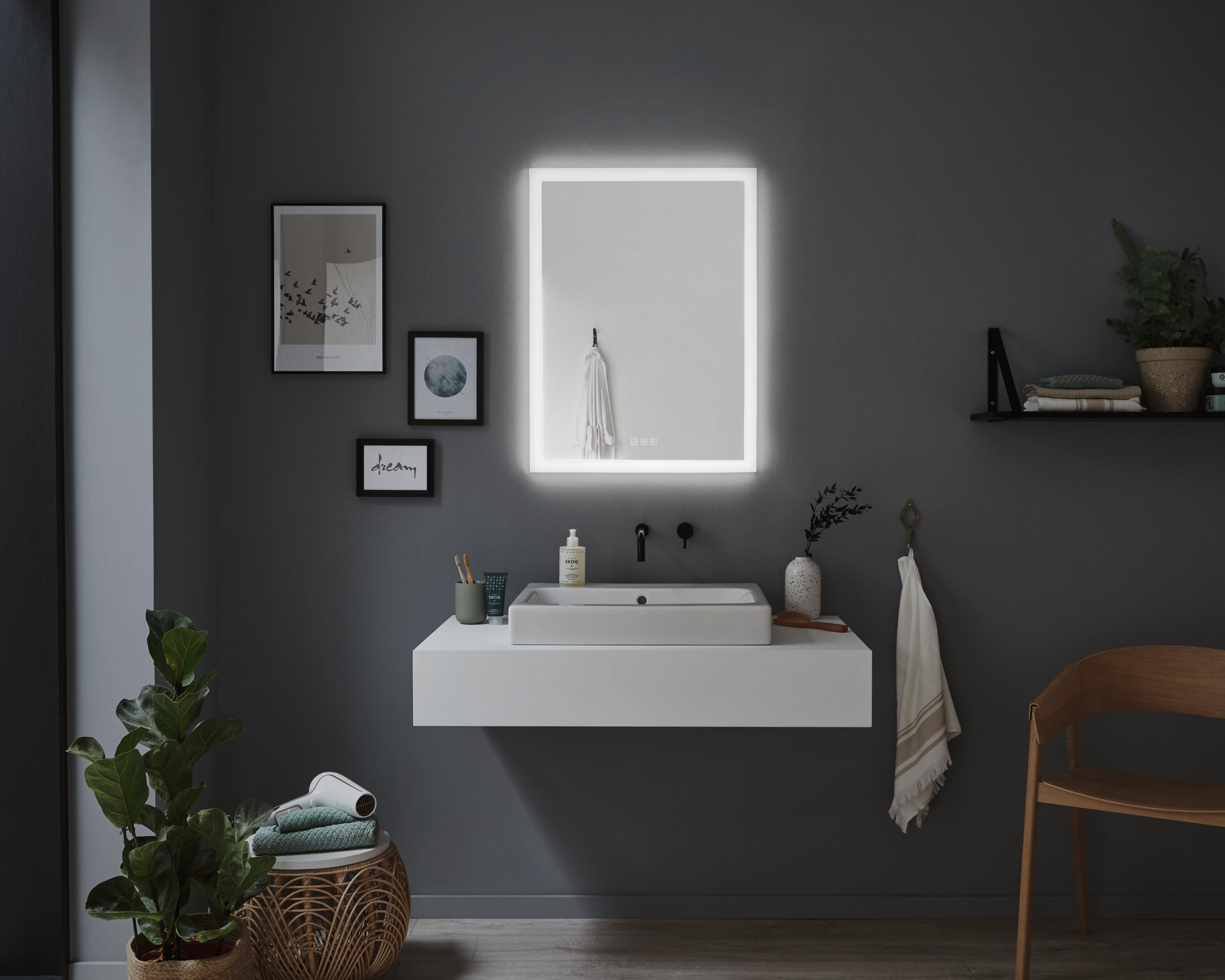 Modernes Badezimmer mit beleuchtetem rechteckigem Spiegel und weißem Waschbecken vor grauer Wand