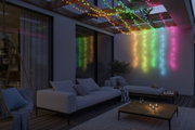 Bunte LED-Lichterketten aus Kunststoff hängen an Holzbalken über moderner Terrasse mit Sofa und Tisch.