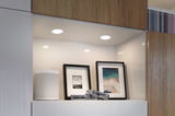 White LED recessed lights in modern wood niche with speaker and two framed pictures.