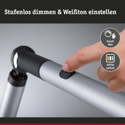 Finger tippt auf schwarzen Touch-Dimmschalter an silbernem Aluminium-Stativarm für LED-Lampe