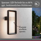 Schwarze LED-Außenwandleuchte an weißer Wand mit energiesparender Beleuchtung und moderner Optik