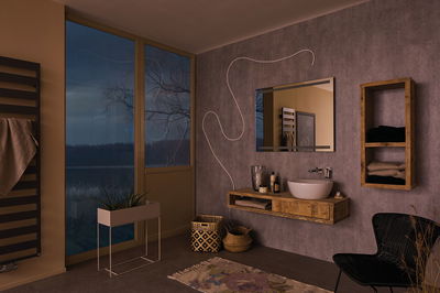 Modern bathroom with wooden vanity, grey wall, and decorative mirror without lighting