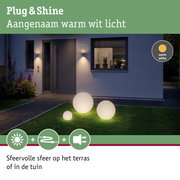 Verlichte bollen met warm wit licht op groen gras voor modern huis voor tuinverlichting