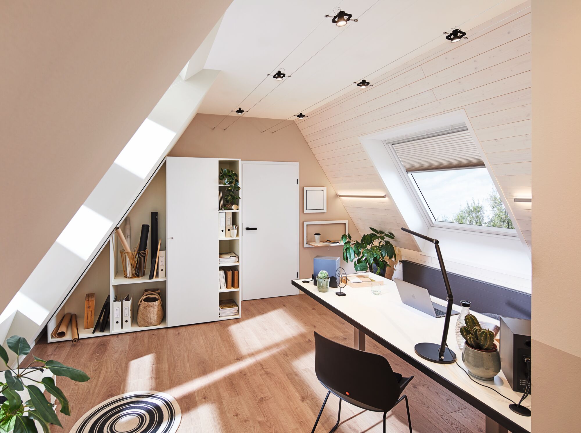 Moderne zolderkamer met wit bureau, zwarte stoel en minimalistische LED-kabelverlichting
