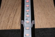 LED-Lichtleiste mit roten LEDs in Aluminiumprofil zwischen zwei Holzplatten für indirekte Beleuchtung