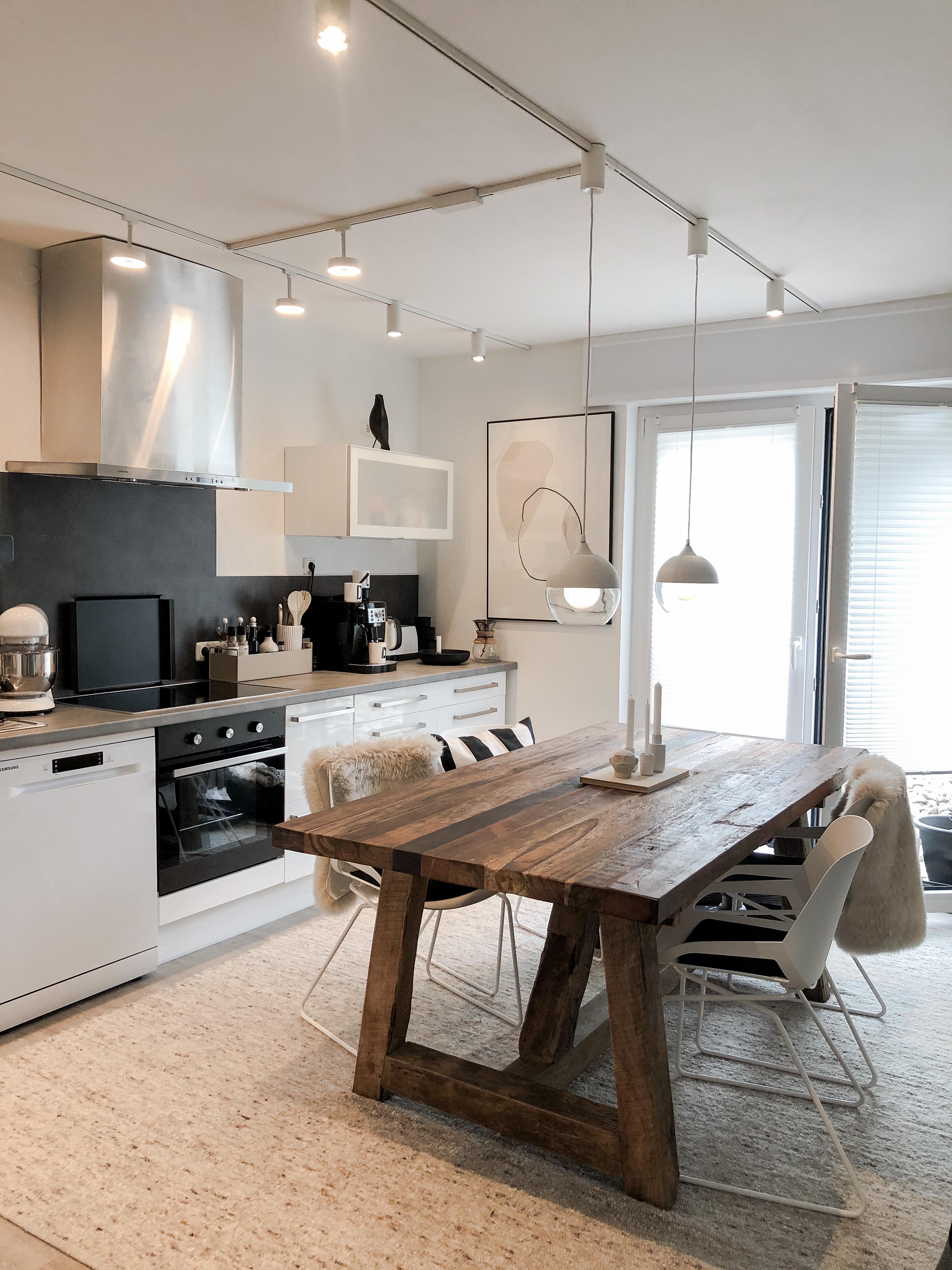 Moderne Küche mit rustikalem Holztisch, weißen Stühlen und minimalistischer LED-Deckenbeleuchtung