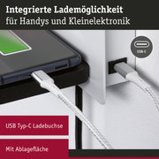 Nahaufnahme eines USB Typ-C Ladeanschlusses mit integriertem Ladekabel und Ablagefläche für Handys