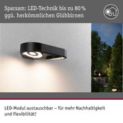 Schwarze LED-Außenwandleuchte mit energiesparender Technik und austauschbarem Modul an weißer Wand