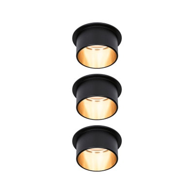 Trois spots encastrés noirs avec lumière blanche chaude pour un éclairage intérieur moderne.